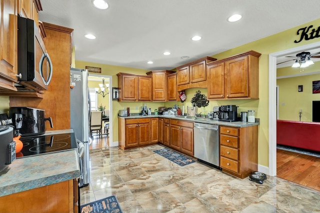 kitchen featuring ceiling fan, stainless steel appliances, and sink