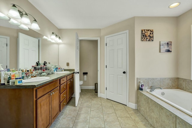 bathroom with tile patterned floors, toilet, tiled bath, and vanity