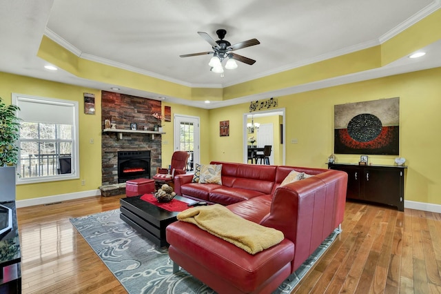 living room with a tray ceiling, a wealth of natural light, ornamental molding, and hardwood / wood-style flooring