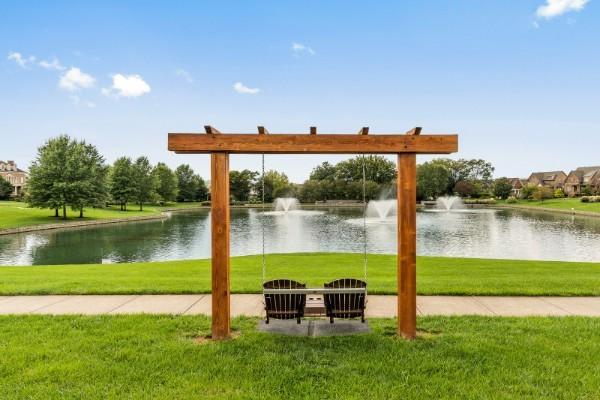 view of property's community with a lawn and a water view