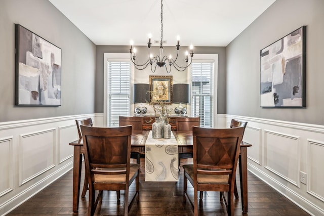 dining space featuring dark wood-type flooring and a notable chandelier