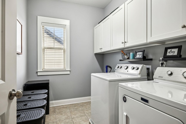 clothes washing area with light tile patterned floors, washing machine and dryer, and cabinets