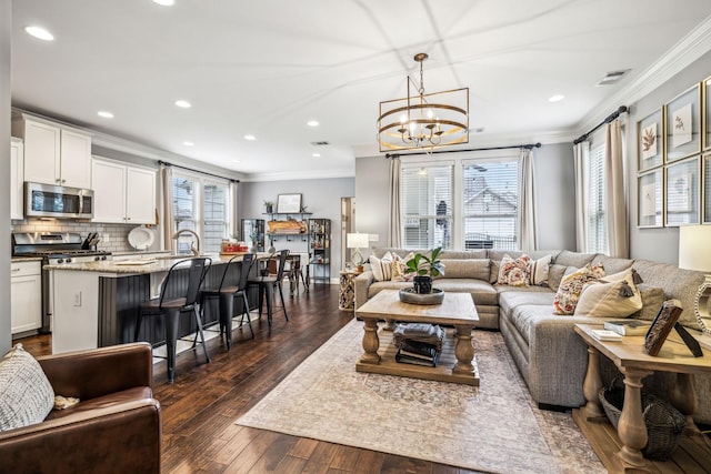 living room with sink, crown molding, dark wood-type flooring, and a wealth of natural light