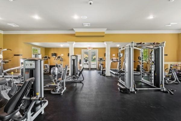 workout area with ornamental molding, a healthy amount of sunlight, and decorative columns