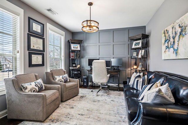 home office featuring light hardwood / wood-style floors and a chandelier