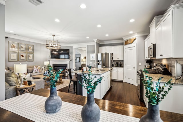 dining room featuring ornamental molding, dark hardwood / wood-style flooring, a chandelier, and sink