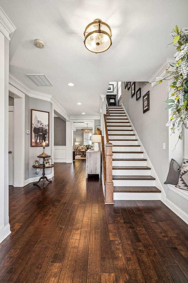 stairway with crown molding and hardwood / wood-style floors