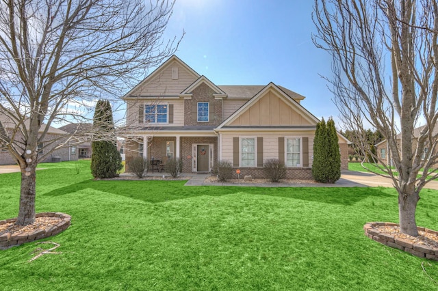 craftsman house with a front lawn, covered porch, brick siding, and board and batten siding