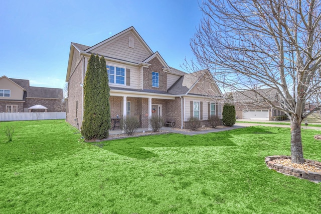 view of front of house featuring a front yard, fence, and brick siding