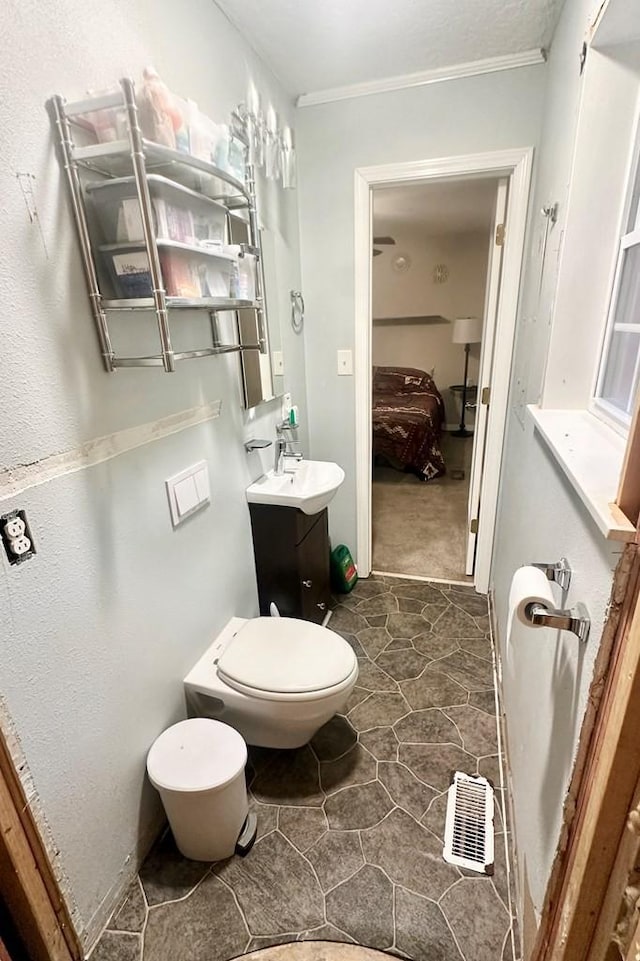 bathroom with vanity, crown molding, and toilet