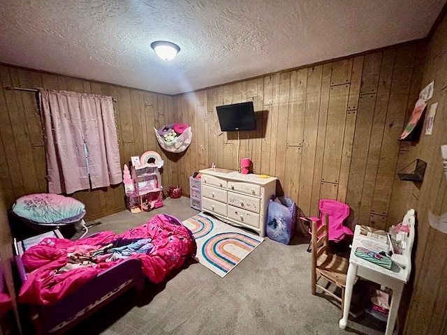 bedroom with wood walls, a textured ceiling, and carpet flooring