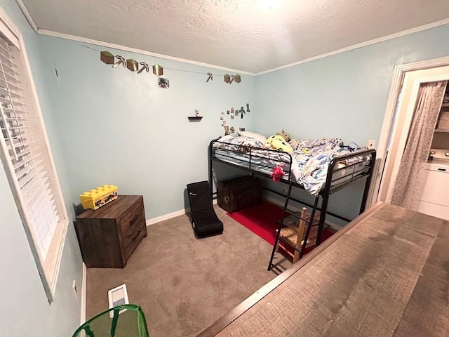 carpeted bedroom featuring ornamental molding, washer / dryer, and a textured ceiling