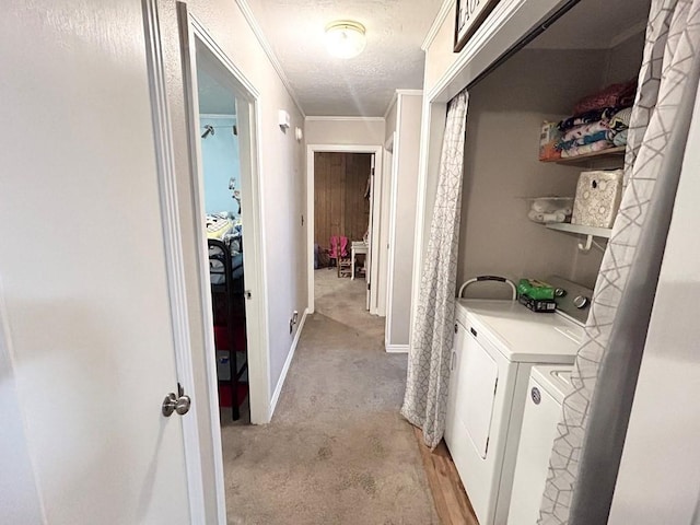 washroom with crown molding, light colored carpet, washing machine and clothes dryer, and a textured ceiling