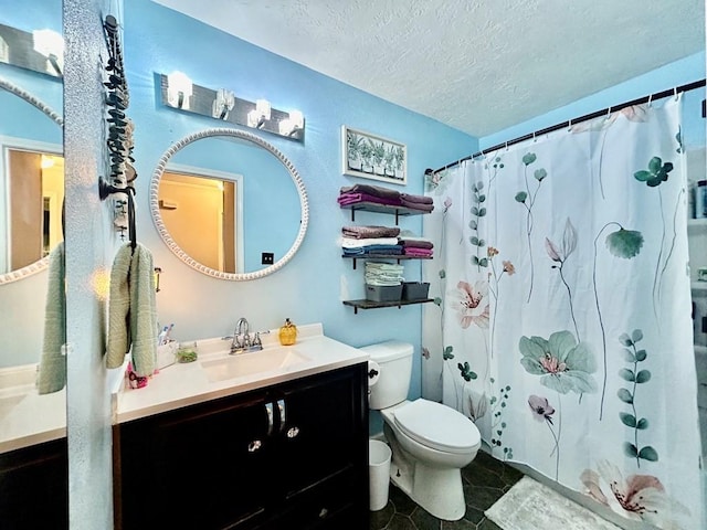 bathroom with vanity, toilet, and a textured ceiling