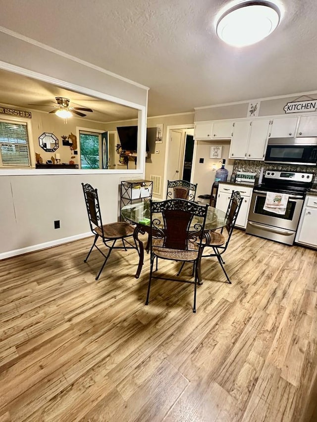 dining room with crown molding, ceiling fan, a textured ceiling, and light hardwood / wood-style floors