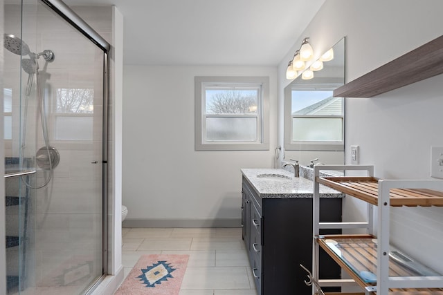 bathroom featuring tile patterned floors, vanity, toilet, and a shower with shower door