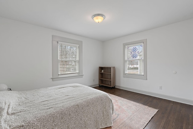 bedroom featuring multiple windows and dark hardwood / wood-style floors