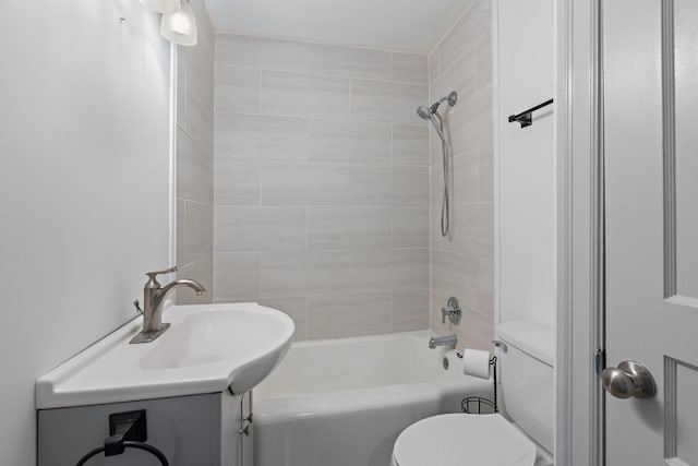 full bathroom featuring tiled shower / bath combo, vanity, and toilet