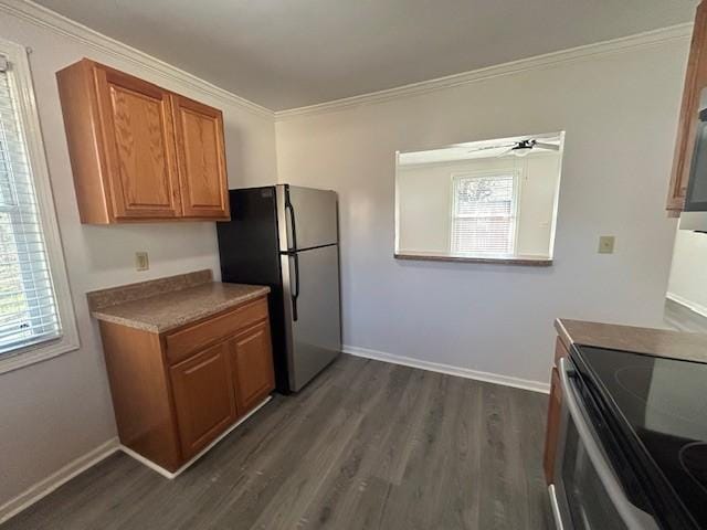 kitchen featuring crown molding, ceiling fan, appliances with stainless steel finishes, and dark hardwood / wood-style floors