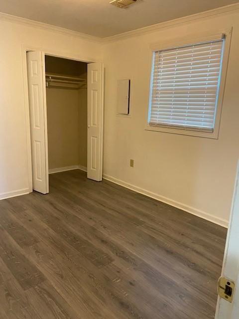 unfurnished bedroom featuring a closet, ornamental molding, and dark hardwood / wood-style floors