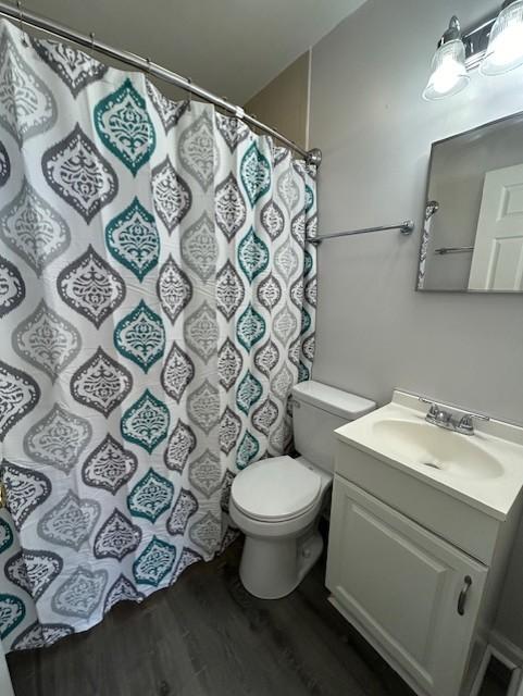 bathroom featuring vanity, hardwood / wood-style flooring, and toilet