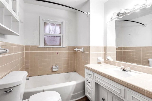 full bathroom featuring vanity, tile walls, toilet, and washtub / shower combination