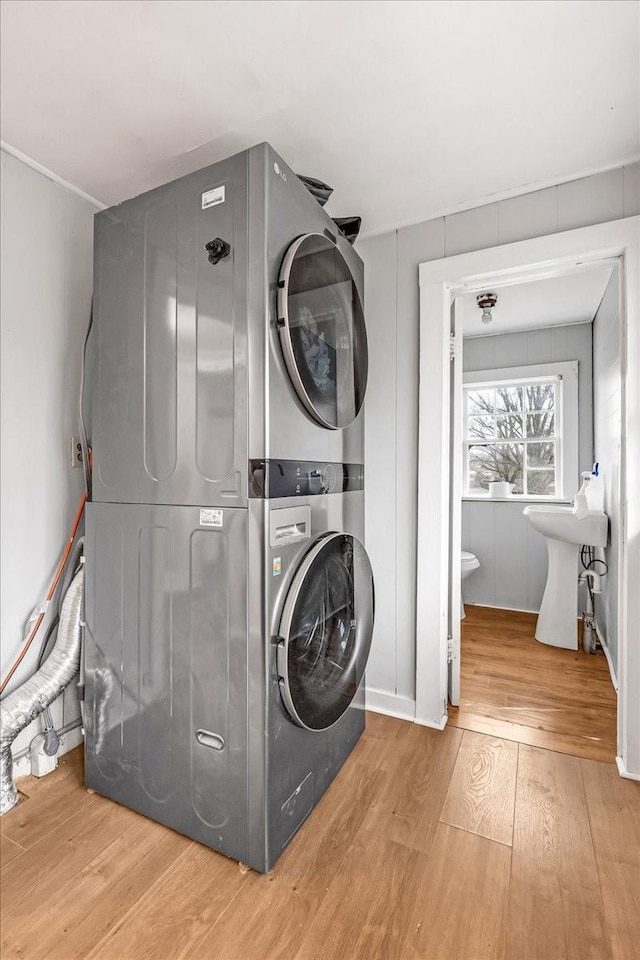 washroom featuring stacked washer / drying machine and hardwood / wood-style floors