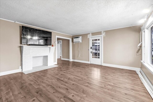 unfurnished living room featuring ornamental molding, a wall mounted AC, hardwood / wood-style floors, and a brick fireplace