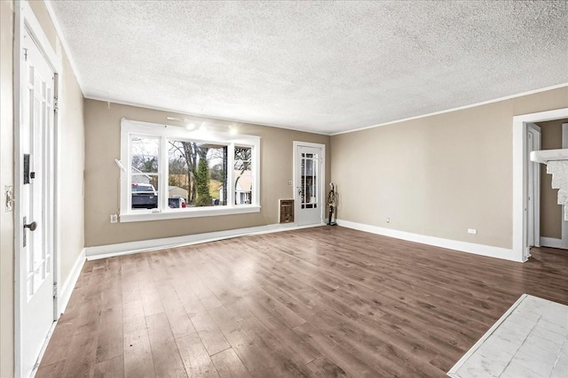 unfurnished living room featuring heating unit, ornamental molding, hardwood / wood-style floors, and a textured ceiling