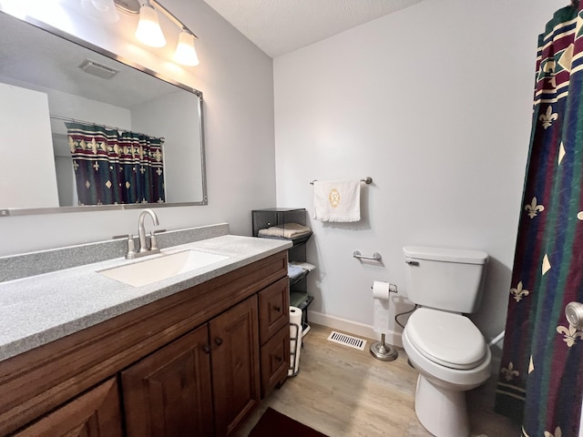 bathroom featuring vanity, hardwood / wood-style flooring, and toilet