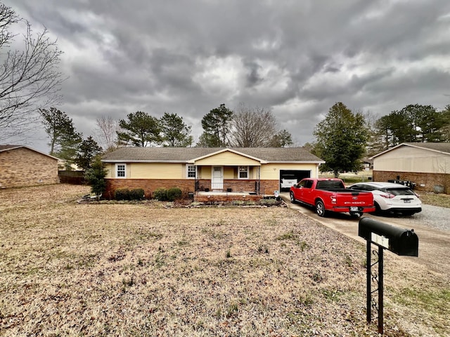 ranch-style house featuring a garage, a front yard, and covered porch