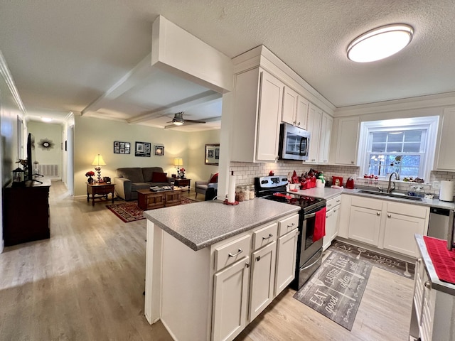 kitchen with sink, white cabinetry, light hardwood / wood-style flooring, kitchen peninsula, and stainless steel appliances