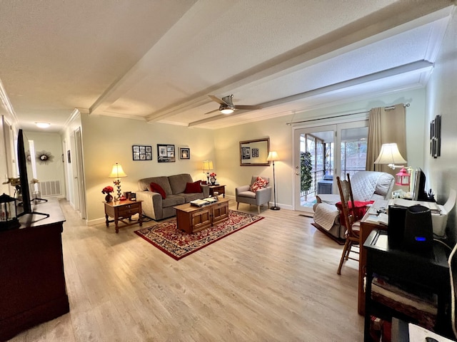 living room featuring light hardwood / wood-style flooring, ceiling fan, ornamental molding, a textured ceiling, and beamed ceiling