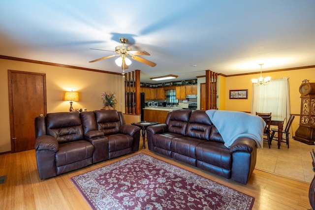 living room featuring ceiling fan with notable chandelier, light hardwood / wood-style flooring, and ornamental molding