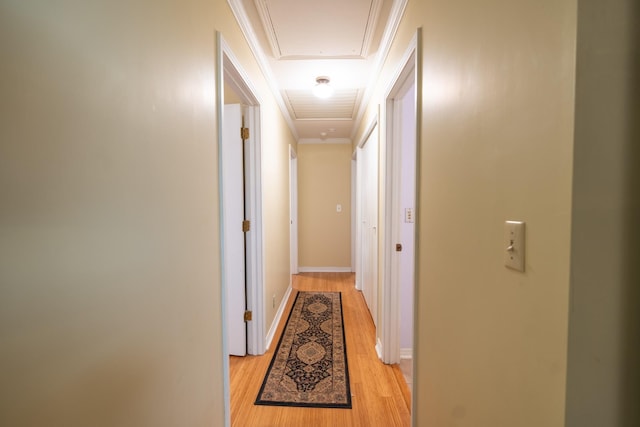 hallway featuring ornamental molding and light hardwood / wood-style floors