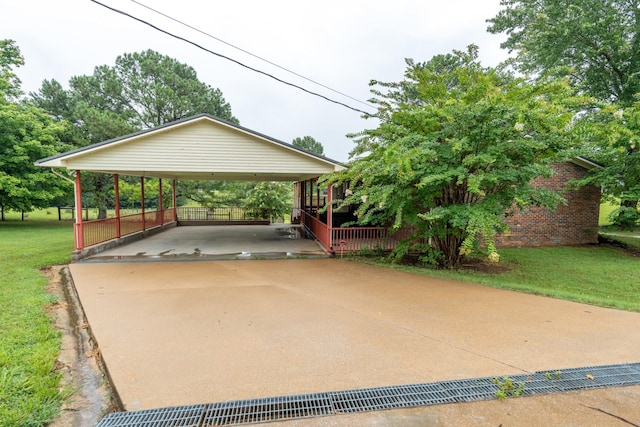 view of parking / parking lot featuring a lawn and a carport