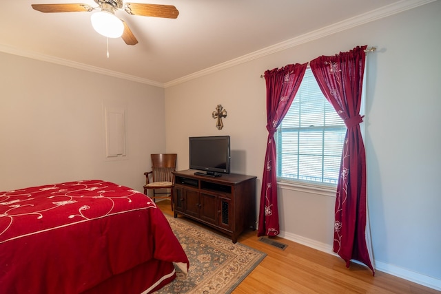 bedroom with ceiling fan, ornamental molding, and light hardwood / wood-style floors