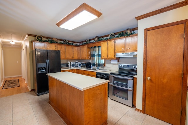 kitchen featuring light tile patterned floors, sink, a center island, and appliances with stainless steel finishes