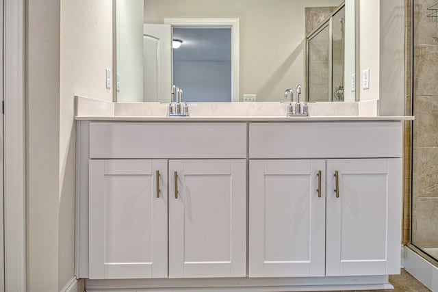 bathroom with vanity and a shower with door