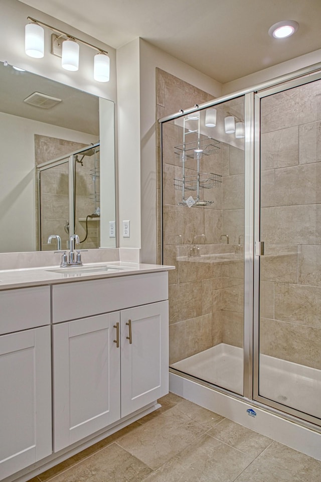 bathroom with tile patterned flooring, vanity, and an enclosed shower