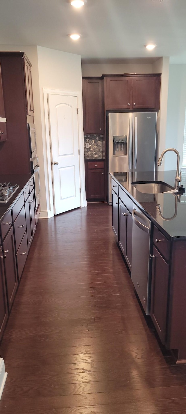 kitchen featuring stainless steel appliances, dark hardwood / wood-style floors, sink, and dark brown cabinets