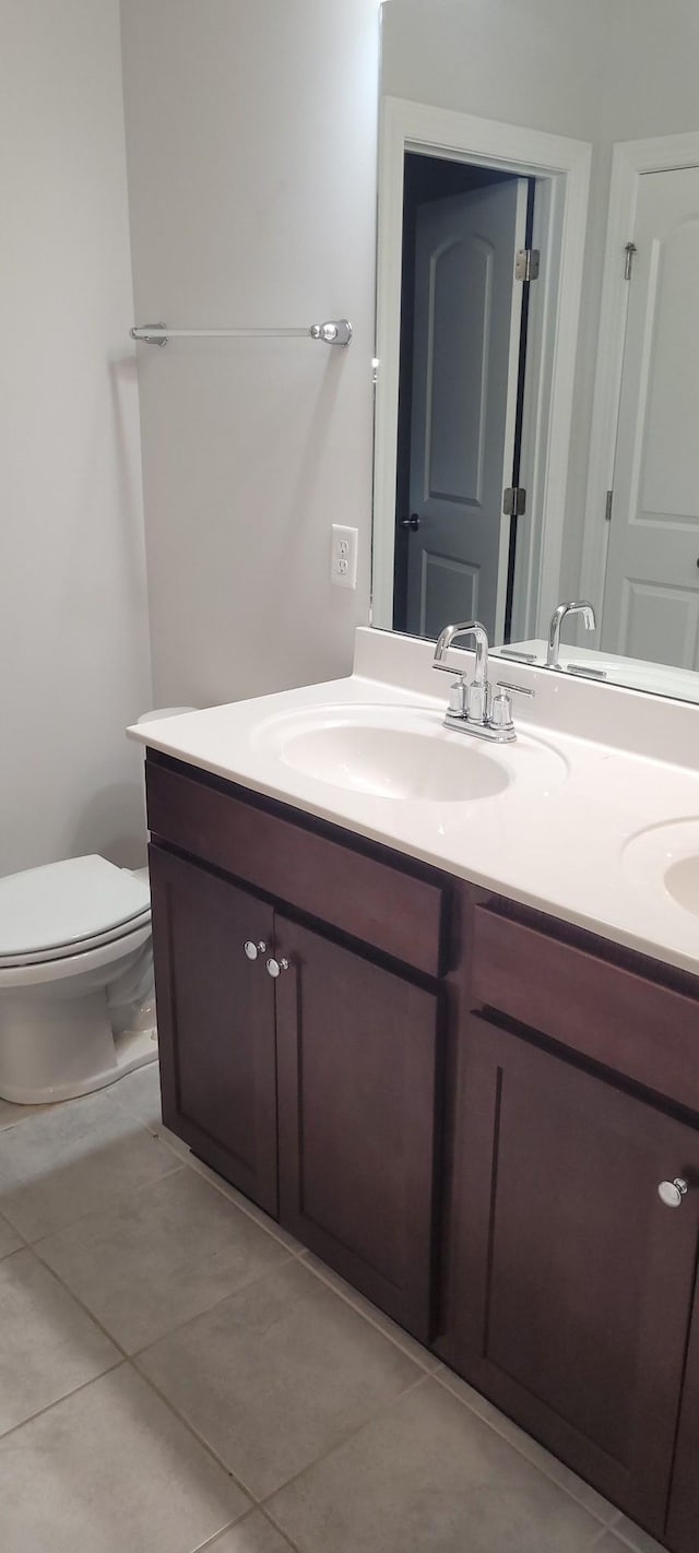 bathroom with tile patterned flooring, vanity, and toilet