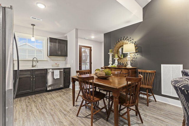 dining area with sink and light hardwood / wood-style flooring