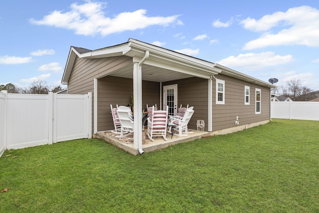 back of property with a yard and a patio area