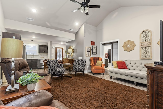 living room featuring ceiling fan, sink, hardwood / wood-style floors, and high vaulted ceiling