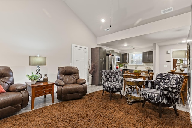 living room with hardwood / wood-style floors and high vaulted ceiling