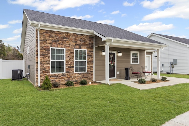 view of front of house with central AC and a front lawn