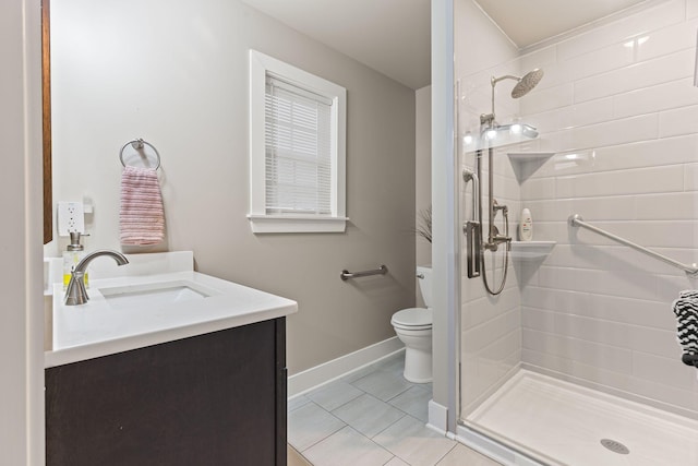 bathroom with vanity, tile patterned floors, toilet, and a tile shower