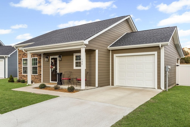 view of front of house with a garage, a front yard, and covered porch