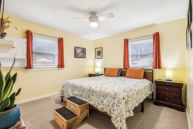 carpeted bedroom featuring multiple windows and ceiling fan